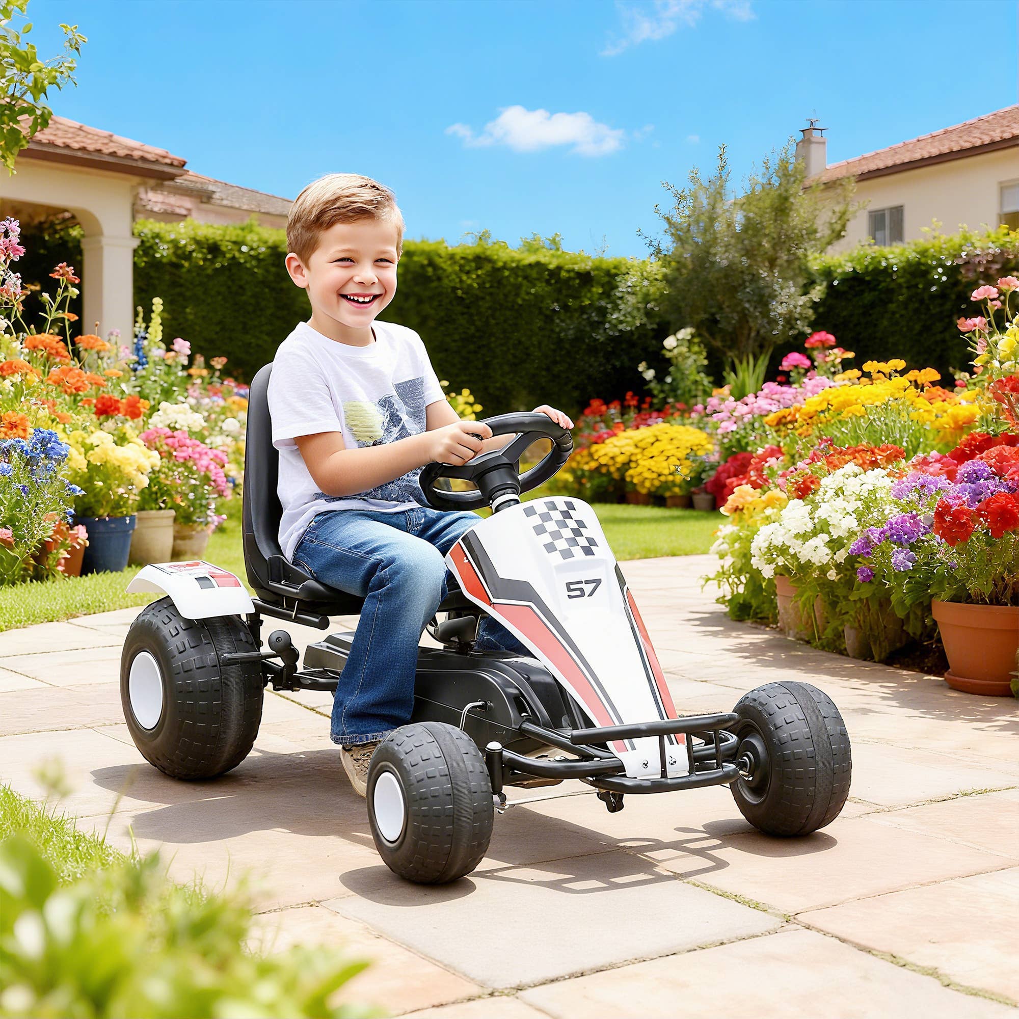 Glad barn der kører på en hvid pedal go-kart udendørs i en blomstrende have.