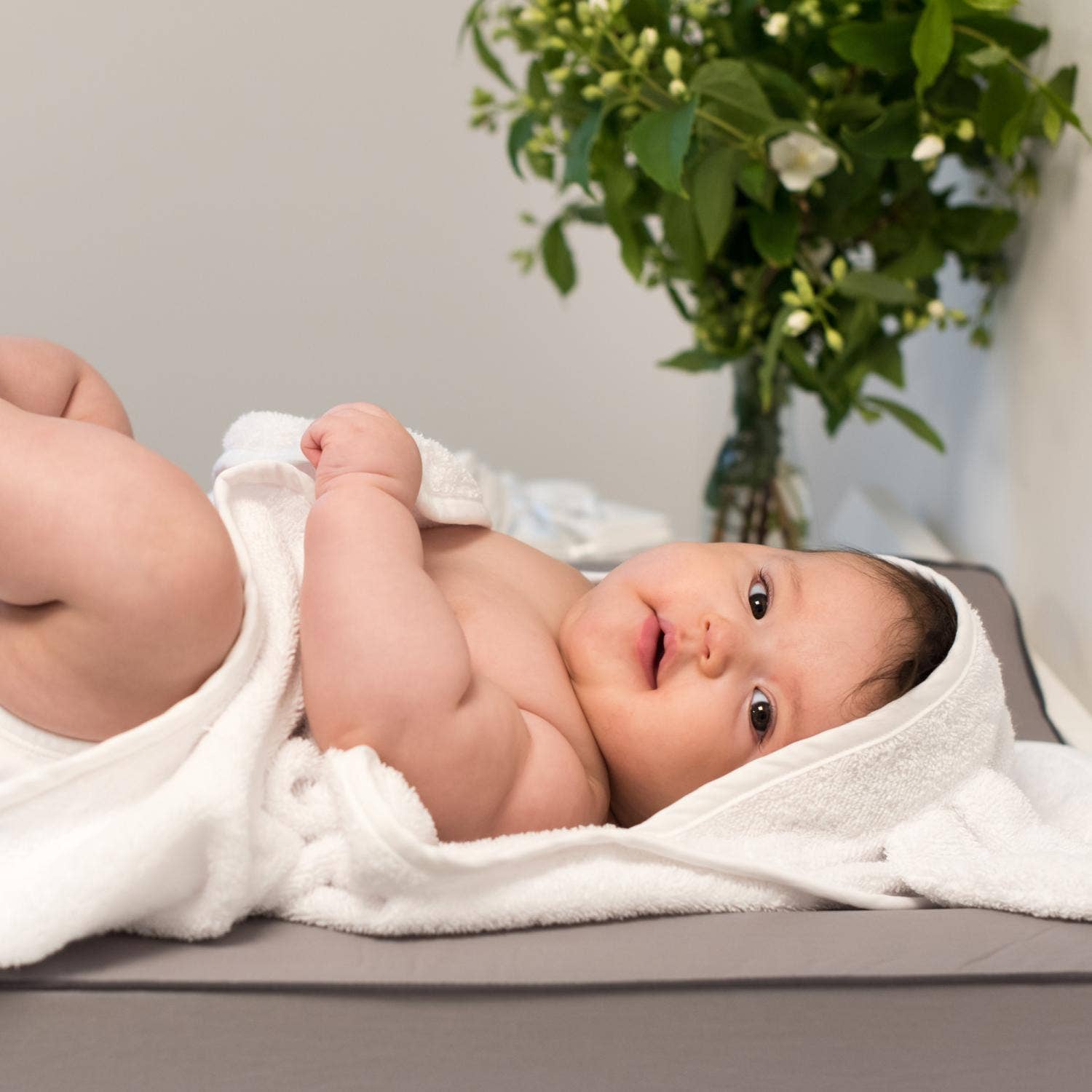 Baby i hvidt økologisk babyhåndklæde med hætte og kaninører