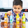 Barn med legemad i træ, frugtjuice og vandflasker på bordet