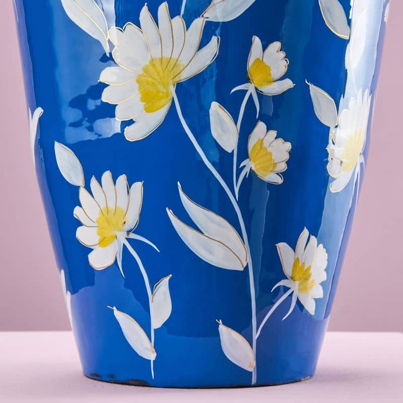 Nærbillede af håndmalede hvide blomster på en blå Margarita metalvase fra WERNS.