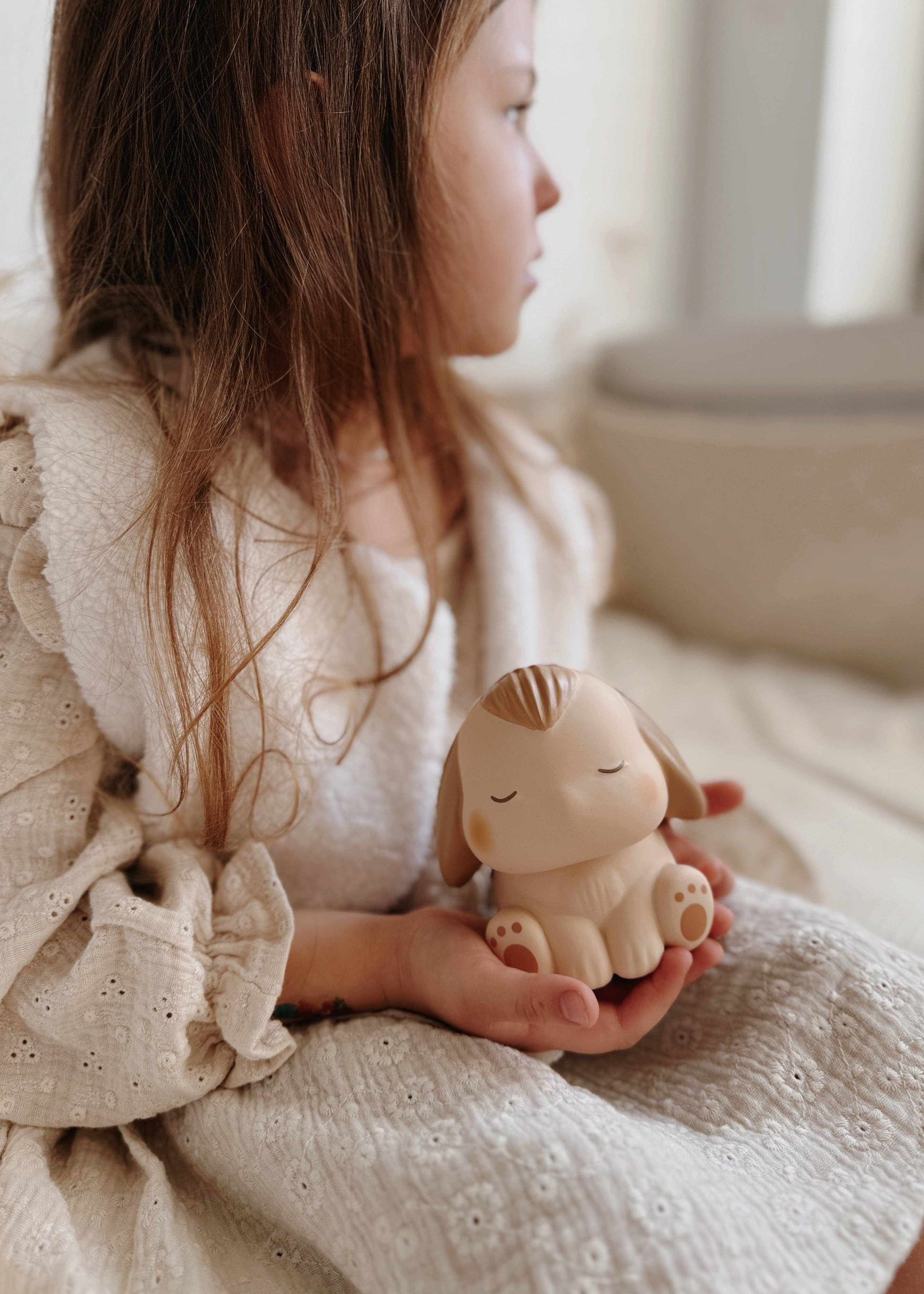 Lille pige der sidder med en blød BunBun kanin squishy fra Squichymals mellem hænderne.