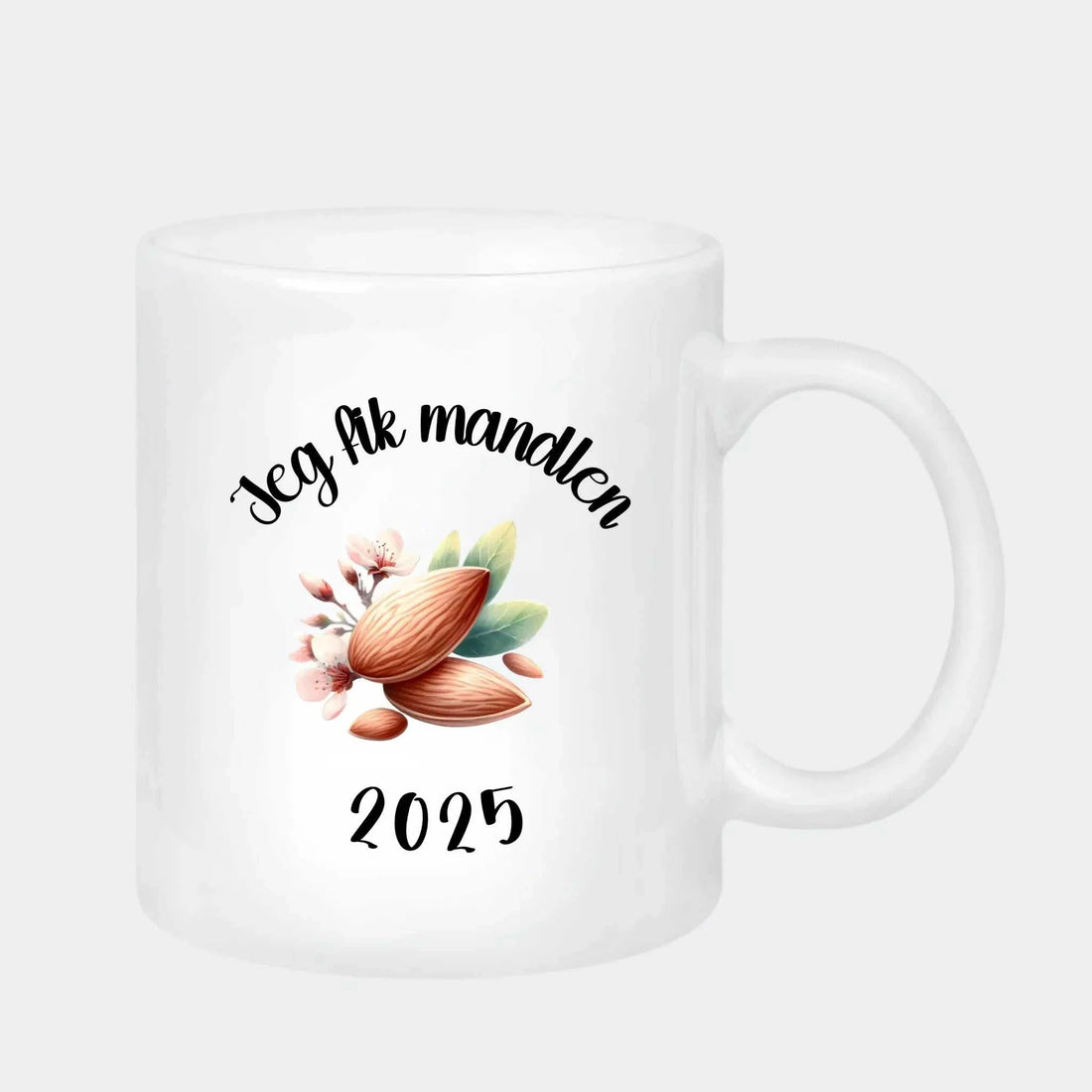 Hvidt keramik krus 330 ml med tekst "Jeg fik mandlen 2025" og mandelmotiv, ideelt som mandelgave.