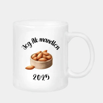White ceramic mug with "Jeg fik mandlen 2025" text and almond illustration, 330 ml, dishwasher safe, perfect mandelgave 2 gift