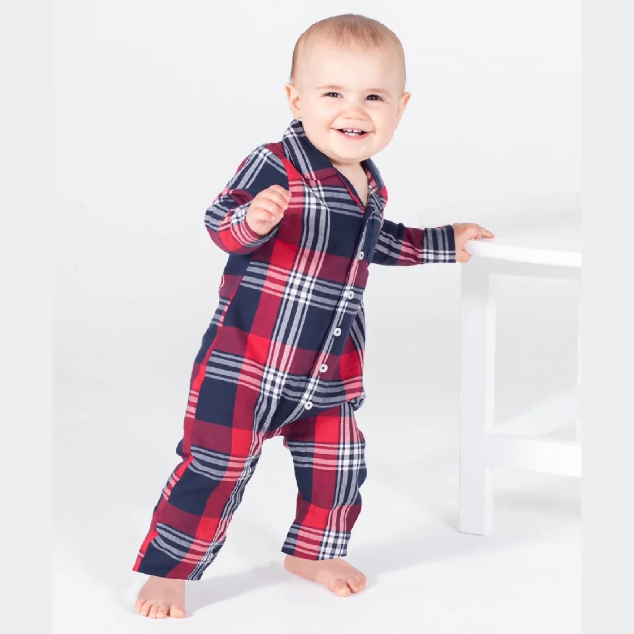 Barn i en rød og blå ternet jumpsuit