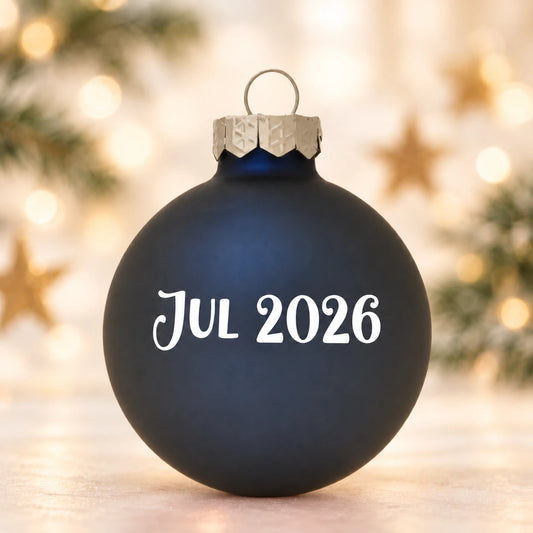 Mat kongeblå julekugle 57 mm med Jul 2026 på diffus julebaggrund med gran og stjerner
