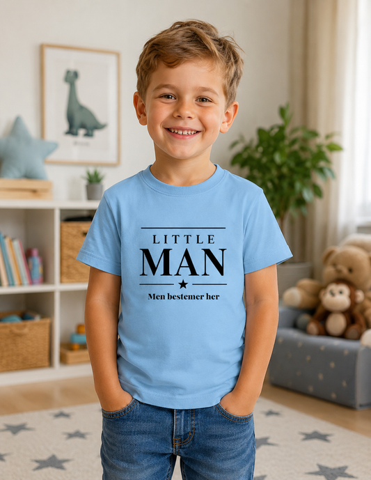 Smilende dreng iført lyseblå t-shirt med teksten Little Man Men bestemmer her.