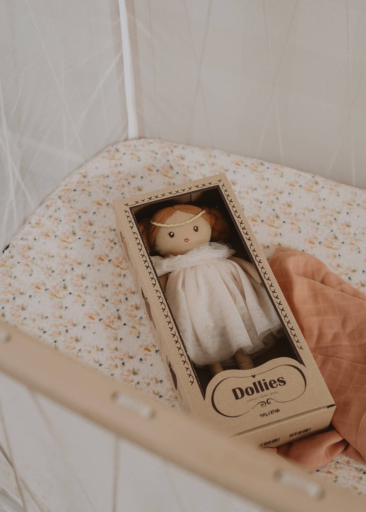 Håndlavet Mrs. Ertha dukke Lilly Toots i original papiræske placeret i en babyseng.