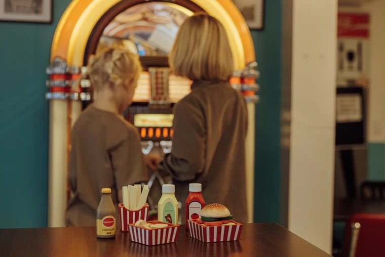 Legemad burger sæt med pommes frites, milk og saucer på bordet