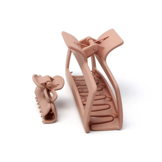 To lyserøde hårklemmer, en lille og en stor, på hvid baggrund