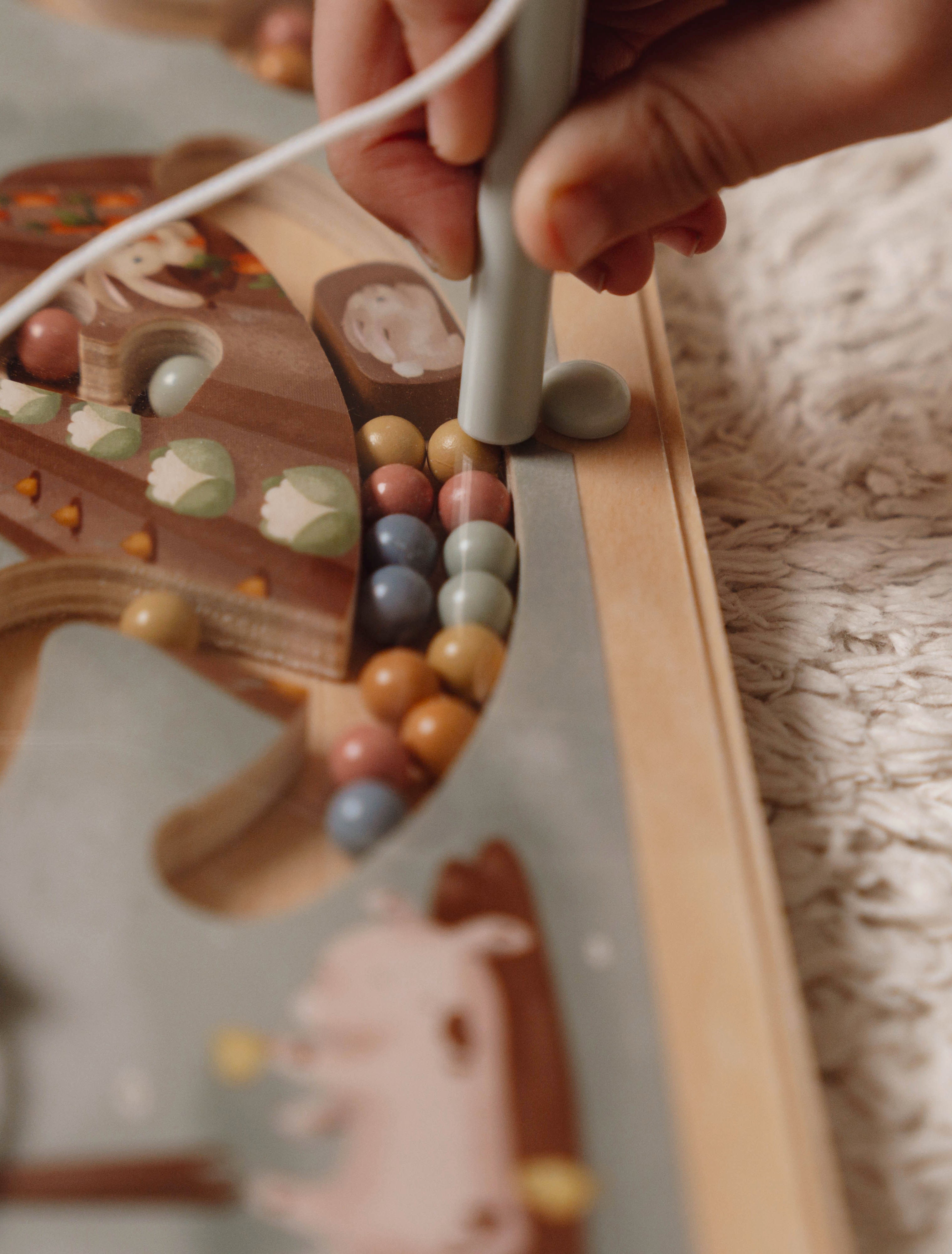 Barn bruger magnetpen til at flytte perler i Little Farm labyrint.