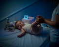 Baby på puslebord med vågelampe i et mørkt rum