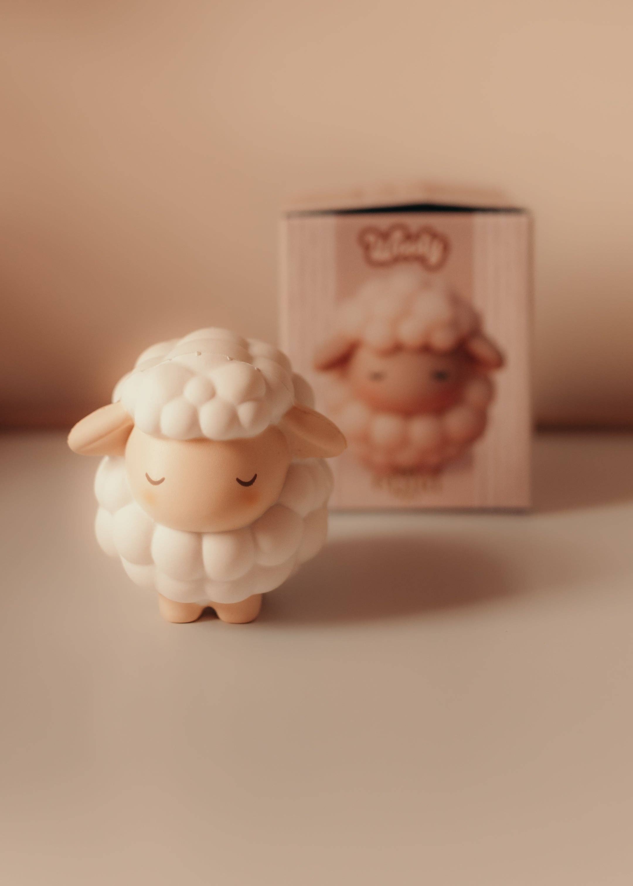 Squichymals Uldne fåret squishy legetøj foran sin æske i bløde nuancer til børn.