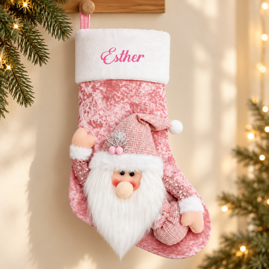 Lyserød julesok med julemand og navnet Esther i enkel julebaggrund med gran og varme lys