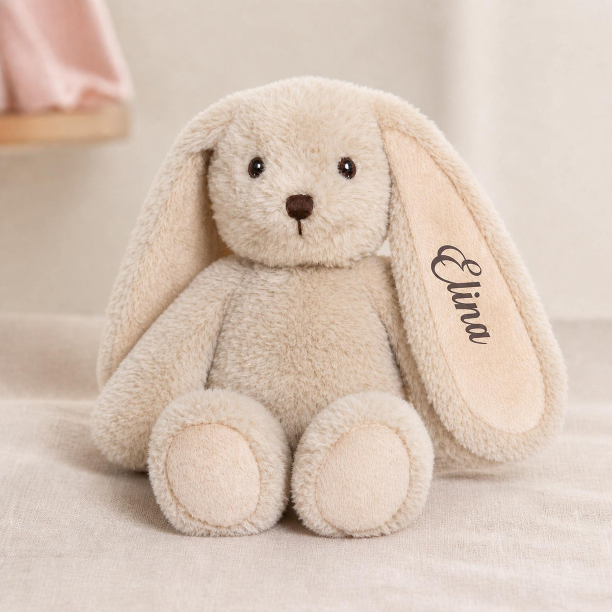 Blød beige plys kaninbamse med navnet Elina broderet på øret.