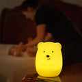 LumiPets natlampe bamse, lyser gult med mor og baby i baggrunden