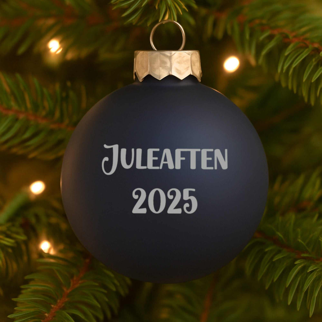 Mat kongeblå julekugle med personlig tekst Juleaften 2025 på juletræ i mat finish 57mm