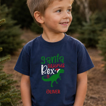 Dreng i en navy blå Santa Saurus Rex t-shirt med juledinosaur og personligt navn.